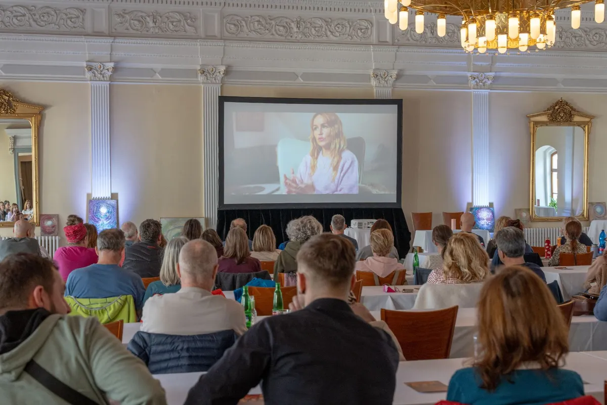 Plný Paspův sál při projekci filmu Esence, pohled zezadu přes publikum na plátno